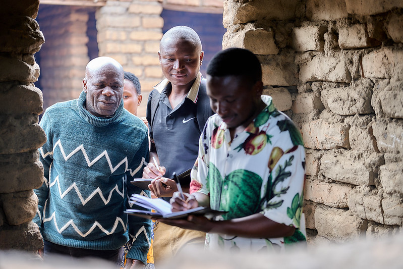 Principal Bahati Kombwe (left) and Kuyenda Collective member Joshua Mpossa (middle) visit the makeshift kitchen at Idugumbi Primary School, Mbeya, Tanzania. Credit: GPE/Mrutu (Trans.Lieu)