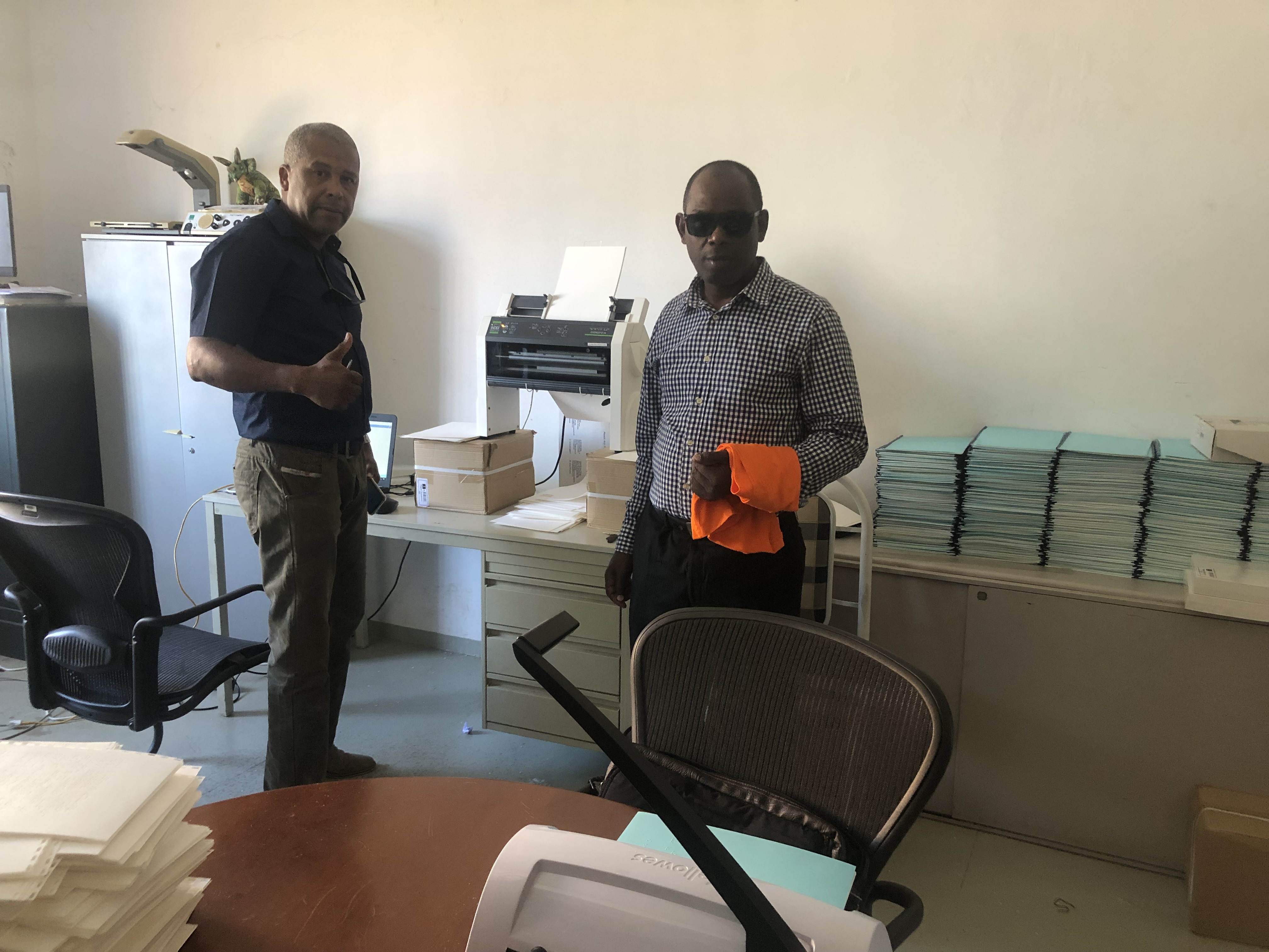 On a visit to the Association of the Visually Impaired of Cape Verde (ADEVIC), Abraão Borges, RNCEPT-CV’s national coordinator, and Dr. Marciano Monteiro, president of ADEVIC and RNCEPT-CV, stand in front of the Braille printer.